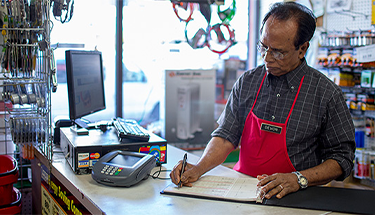 A small business owner works at the sales counter